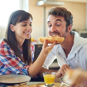 Couple-having-fun-eating-pizza-together